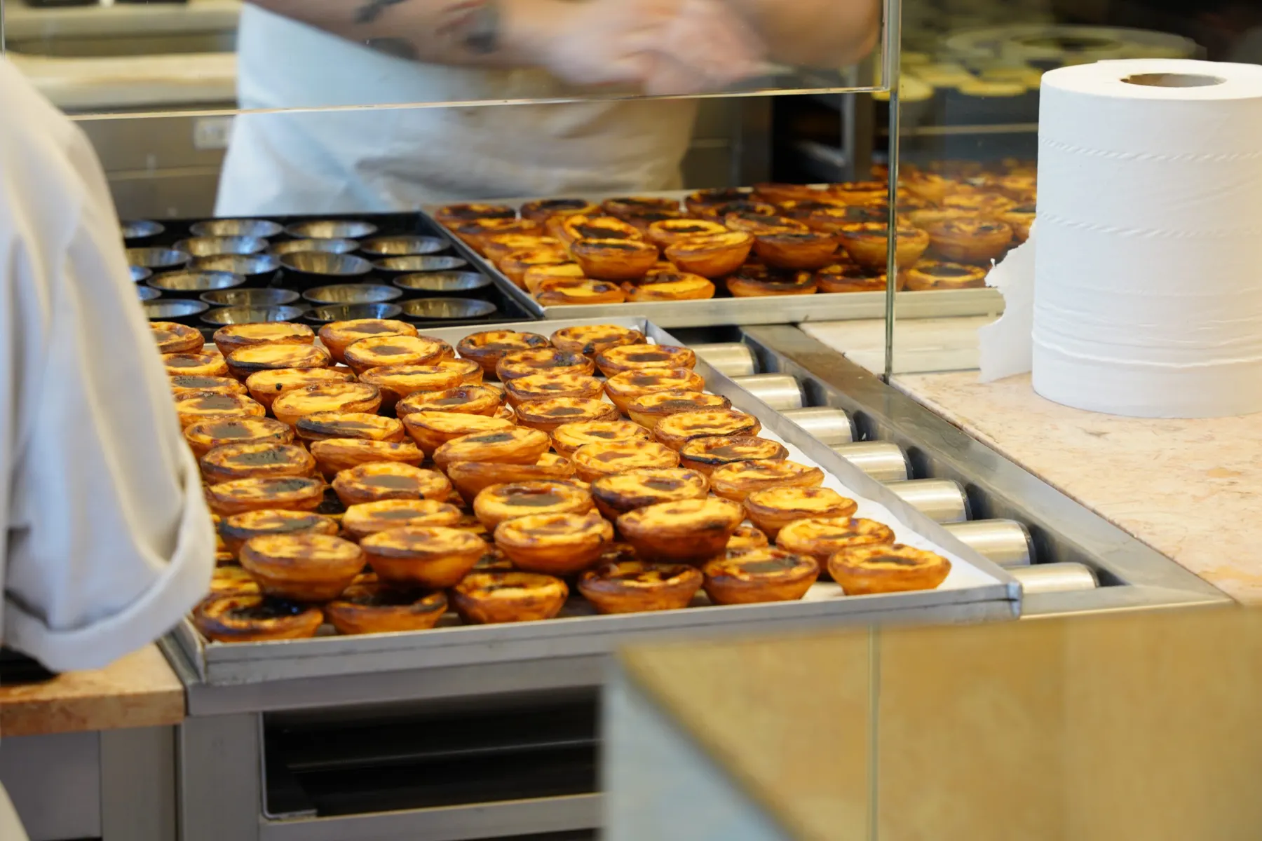 Trays of fresh pastries cooling on a bakery counter