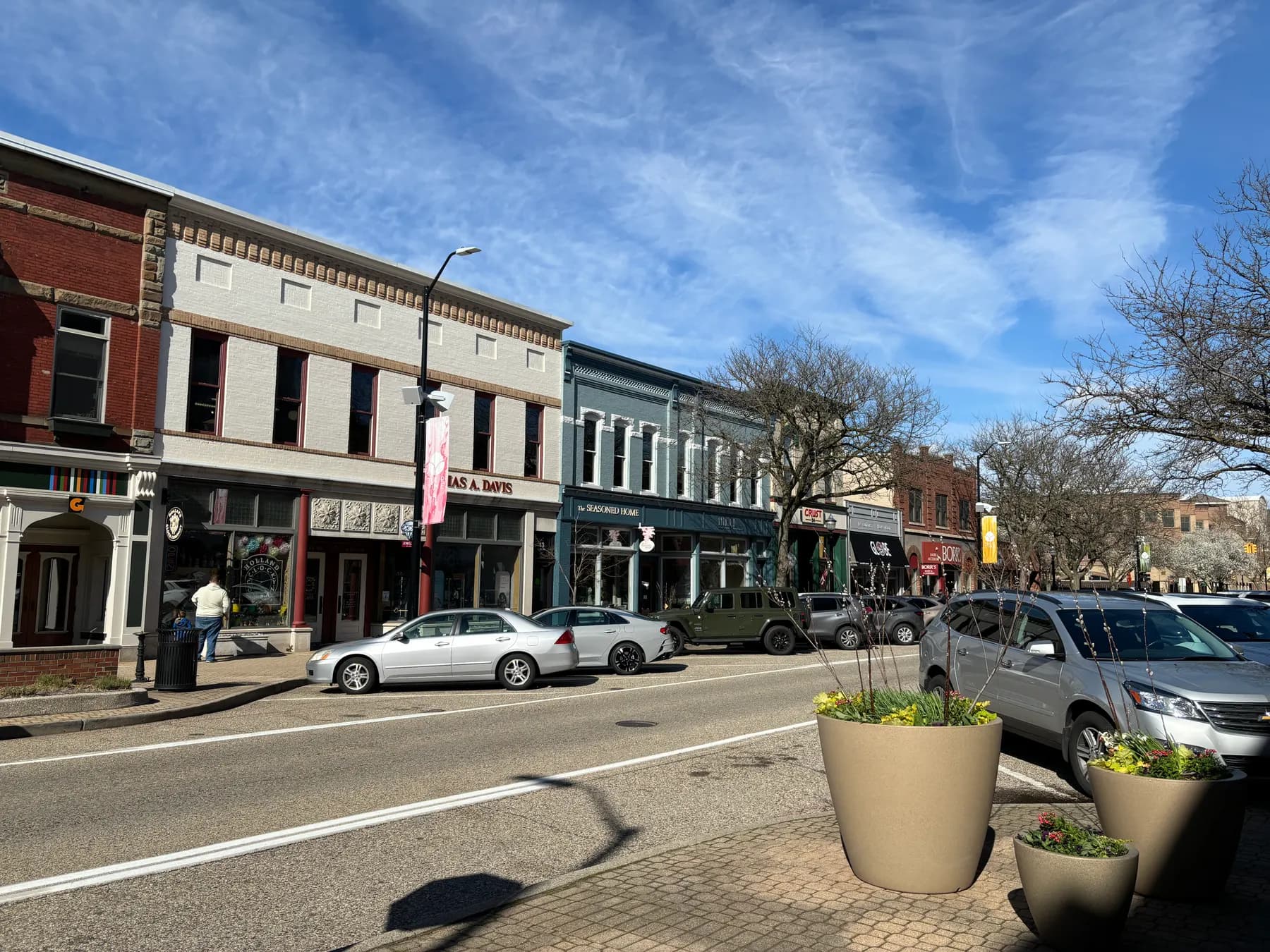 A row of brick storefronts along a small-town main street on a clear day