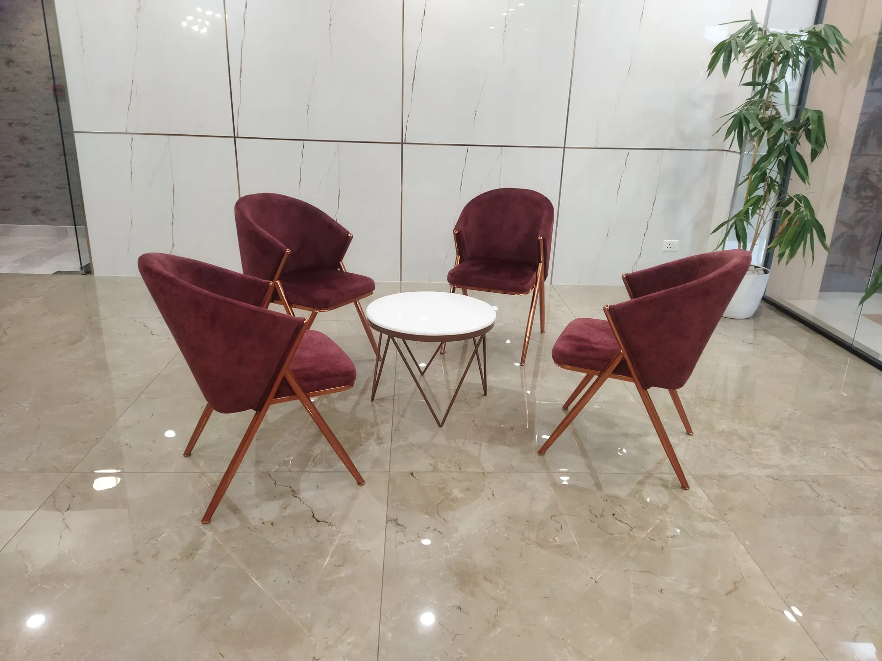 Four upholstered armchairs arranged around a small round table in a bright lobby